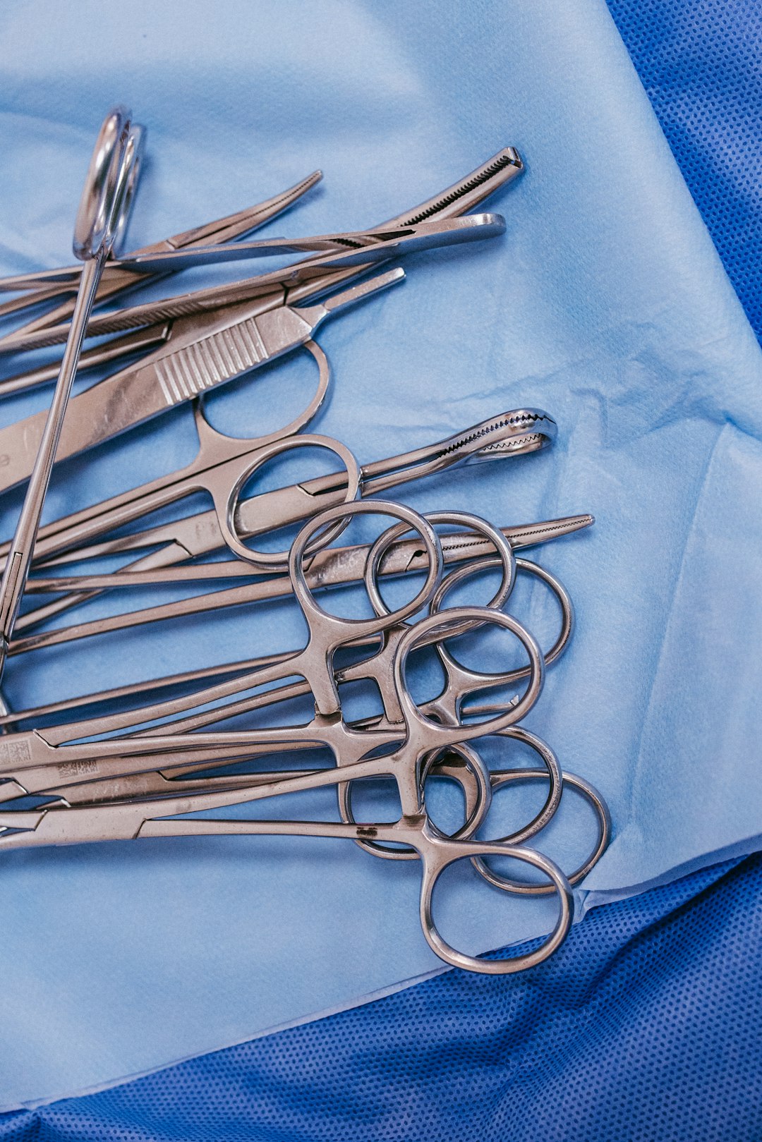 Home A Pile Of Surgical Scissors On A Blue Cloth Ucnh3ldfkce